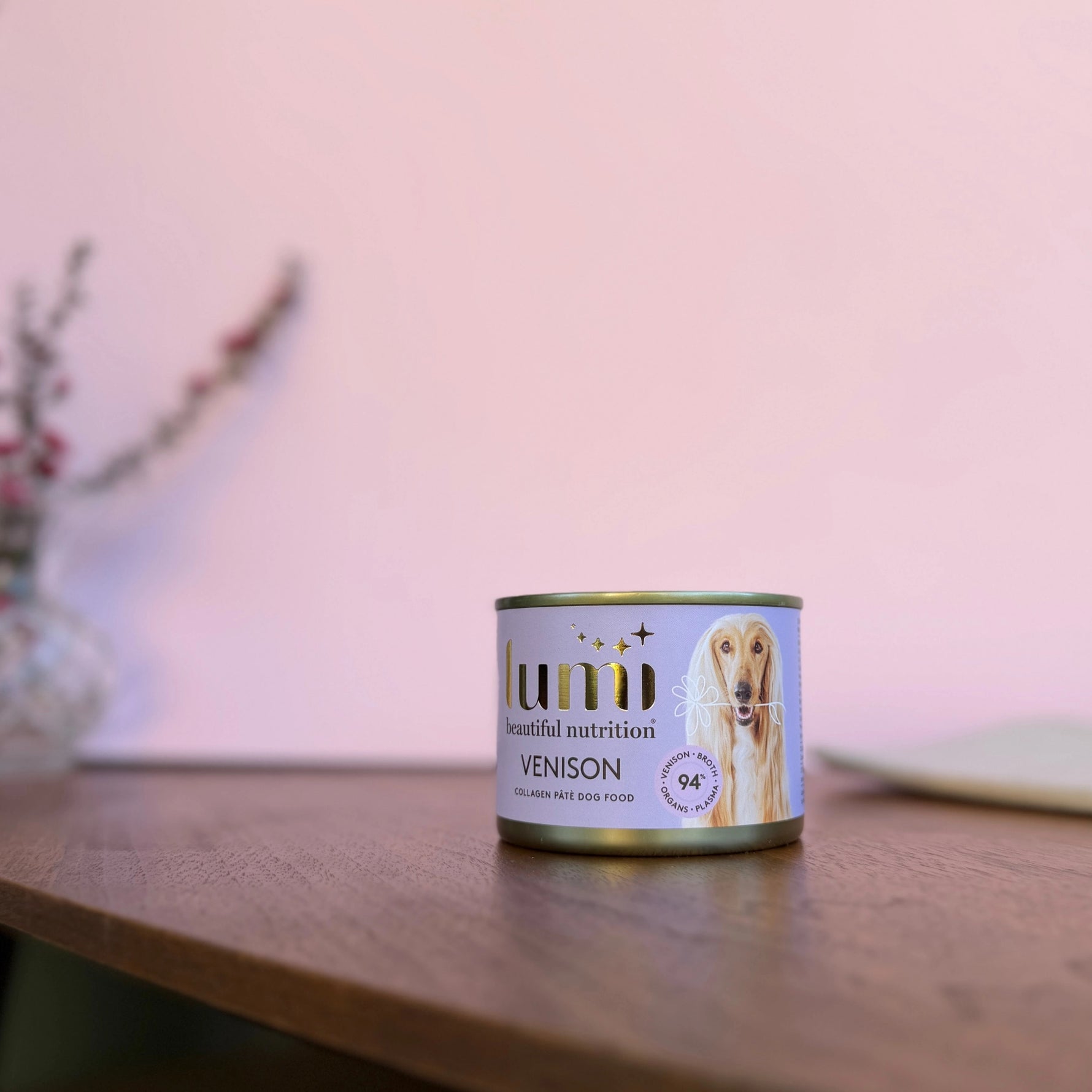 Lumi Venison canned dog food on a wooden table with a blurred background